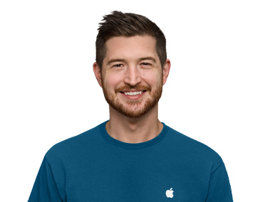 An Apple Store Specialist smiling, wearing a blue Apple shirt