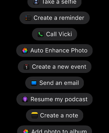 شاشة تعرض طلبات موجّهة إلى Siri AI لاتخاذ إجراءات في التطبيقات، بما في ذلك Take a selfie، وCreate a reminder، وCall Vicki، وRotate photo left، وCreate a new event، وSend an email، وResume my podcast، وCreate a note، وAdd photo to album