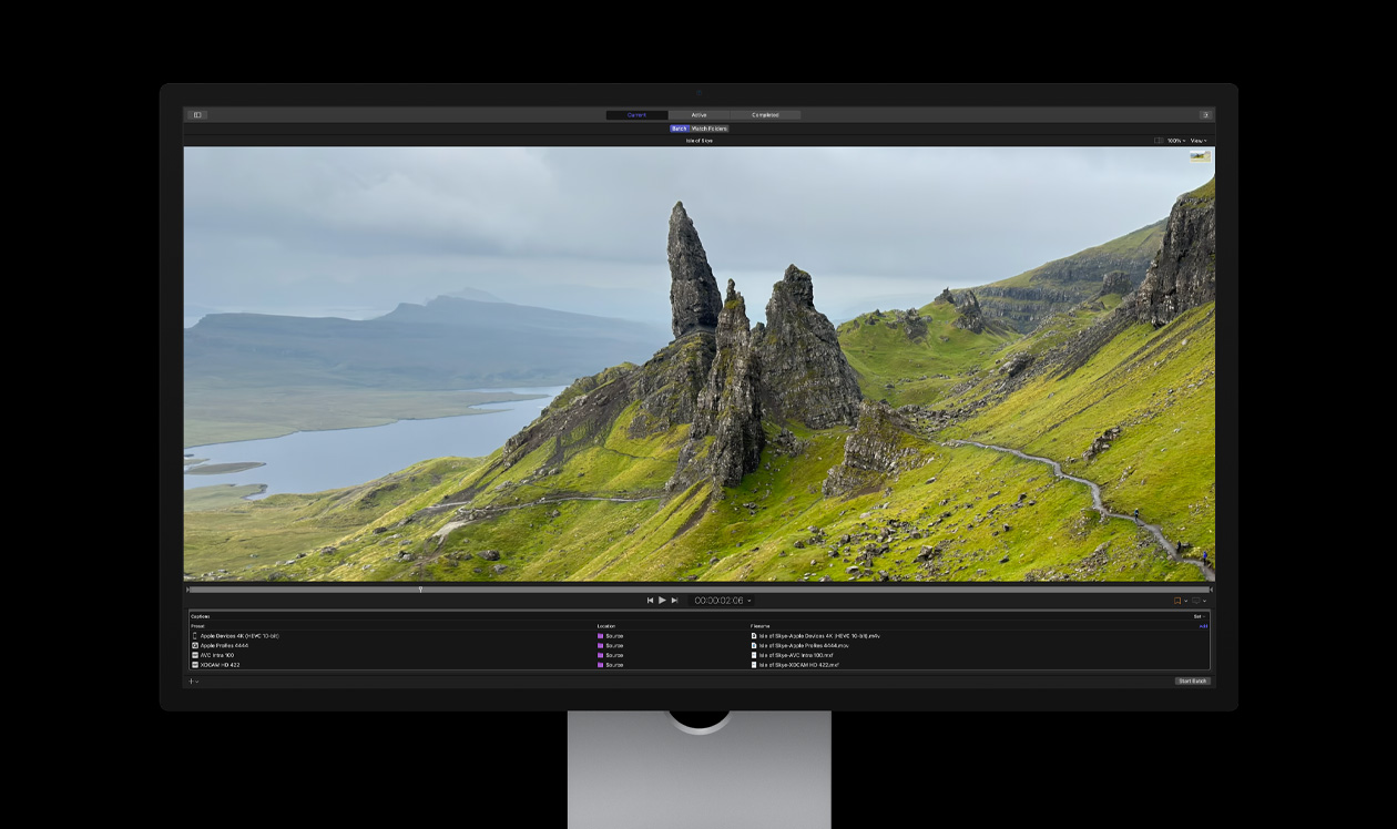 Mac Studio Display screen showing Compressor, rocky crags in barren seaside landscape with green grass, demo of batch export