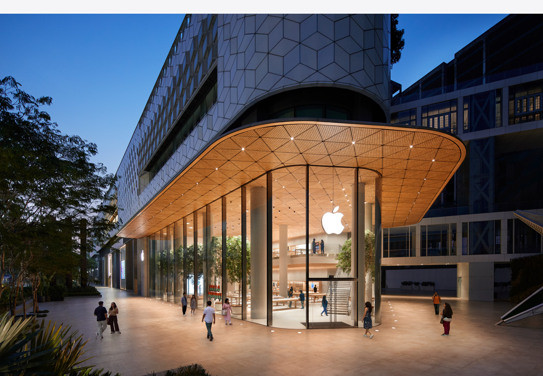 Магазин Apple уночі, скляні вітрини, освітлені зсередини, логотип Apple по центру над вхідними дверима